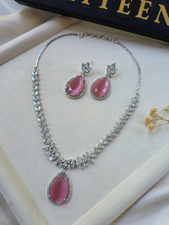 Pink sapphire teardrop necklace and earrings set with CZ halo — white gold plated bridal jewellery — Eliyeen
Close-up of pink sapphire teardrop pendant with cubic zirconia border — Eliyeen
Model wearing pink sapphire statement necklace for wedding — Eliyeen