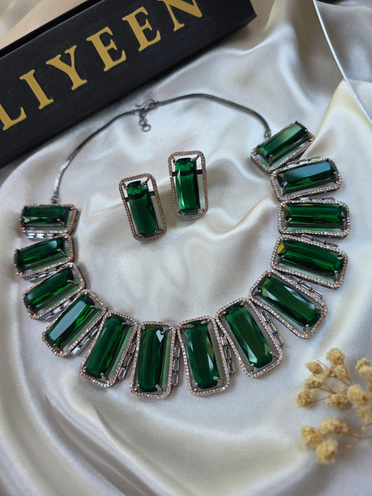 Close-up of rectangular lab-made emerald stone with CZ halo and oxidised gold border — Eliyeen