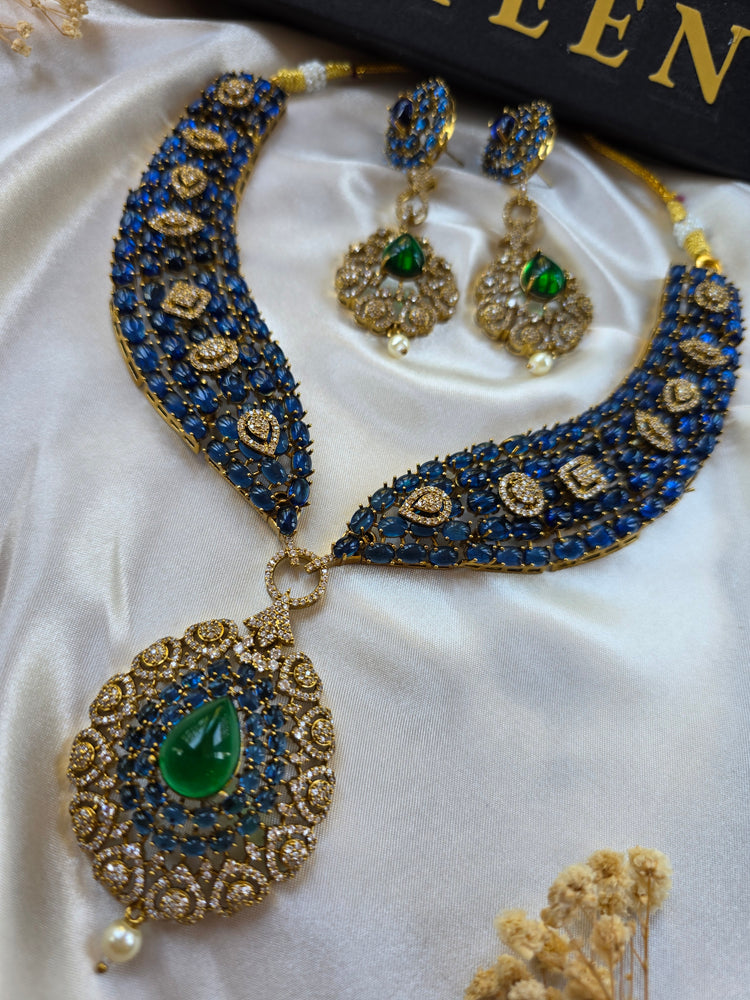 Close-up of blue sapphire choker with central emerald stone and antique gold finish — Eliyeen