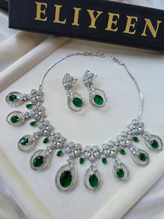Deep emerald green statement necklace and earrings set — white gold plated bridal jewellery — Eliyeen
Close-up of deep emerald green necklace with cubic zirconia detailing — Eliyeen
Model wearing dramatic emerald green statement necklace for wedding — Eliyeen