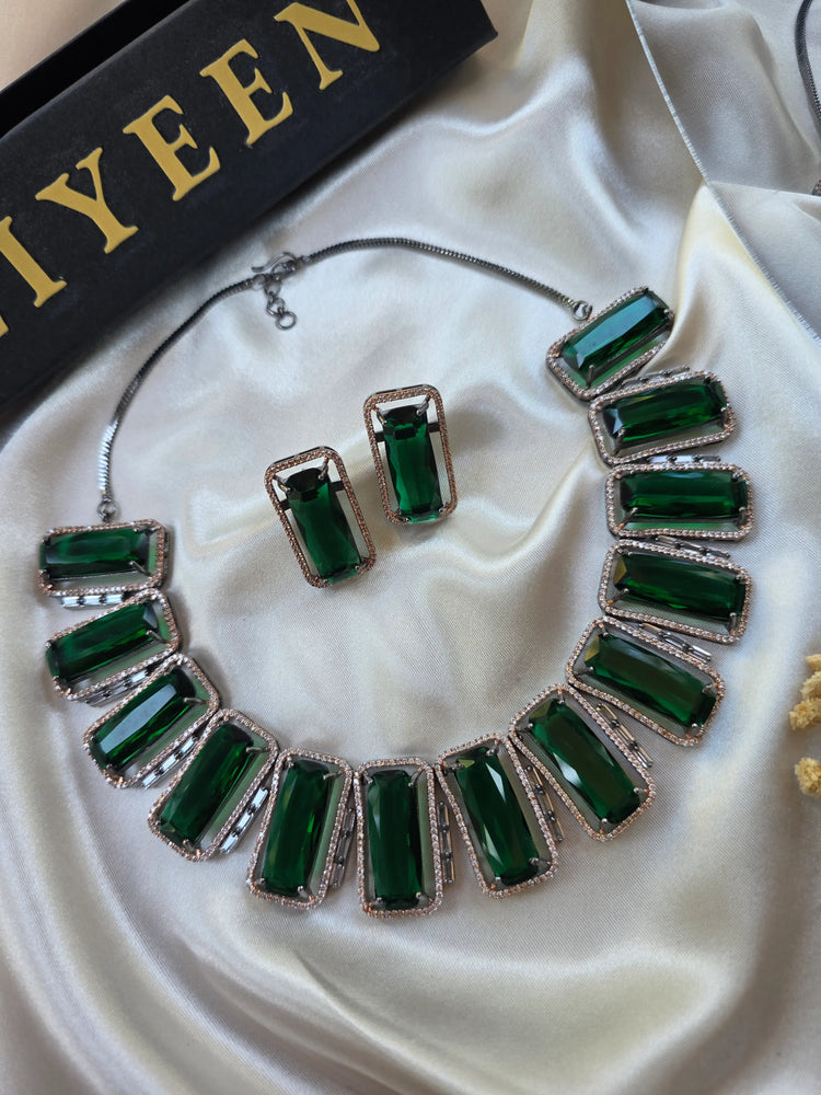 Close-up of rectangular lab-made emerald stone with CZ halo and oxidised gold border — Eliyeen